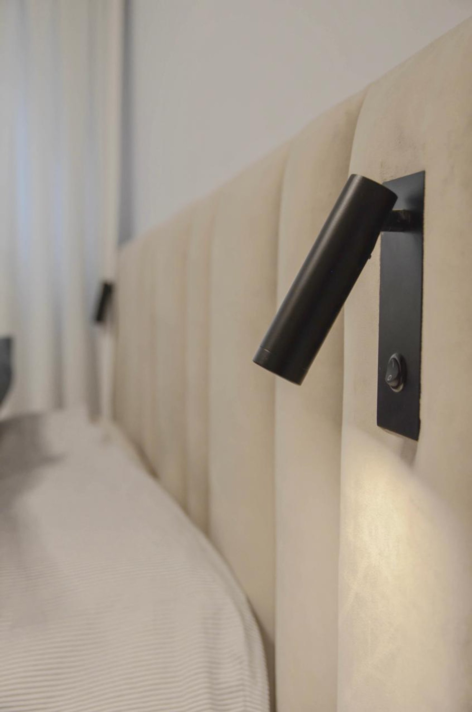 Dormitorio moderno con apliques de pared negros y cabecero beige — proyecto Cordoba, por Eniraestudio, en Buenos Aires